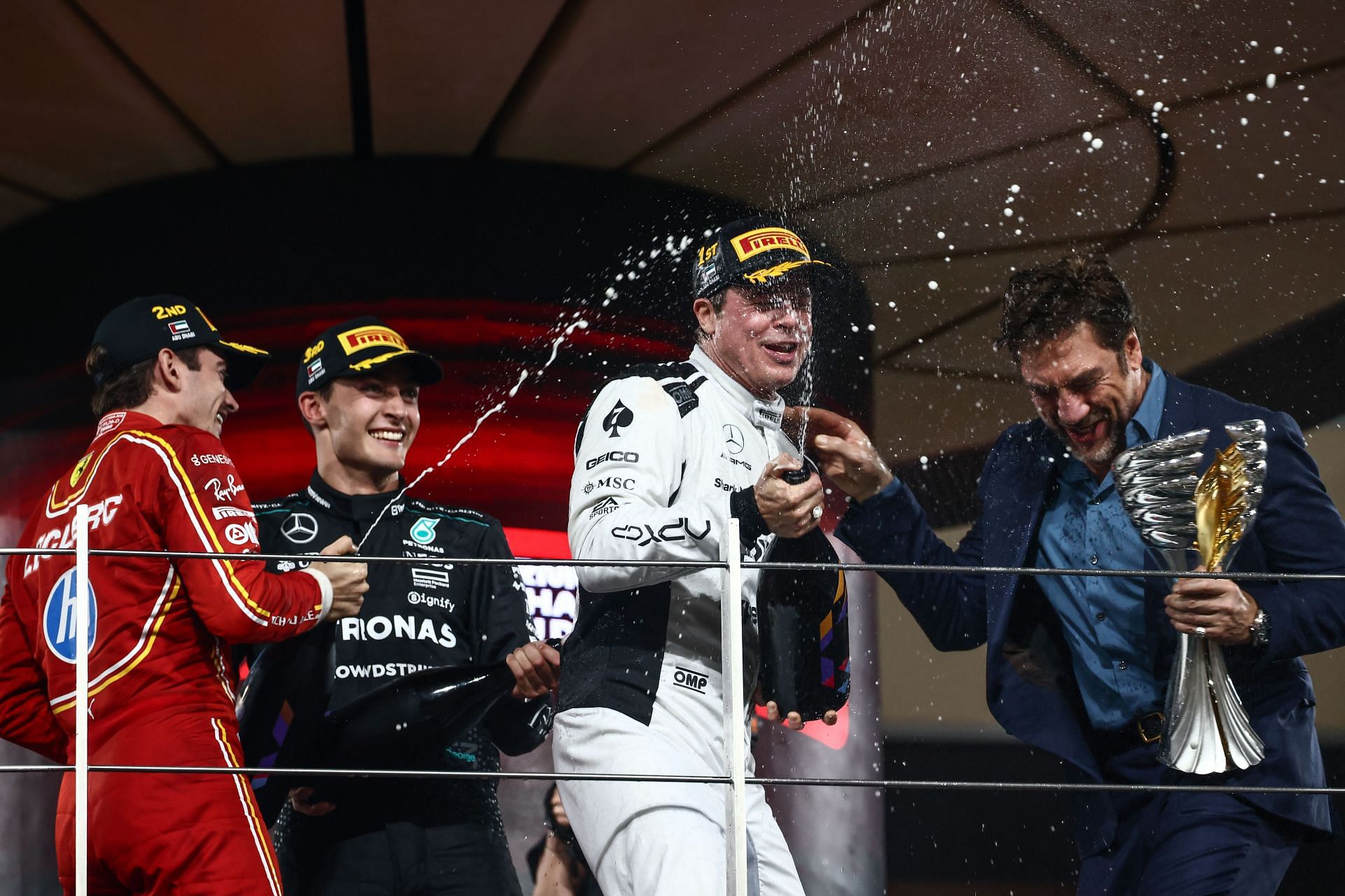 Charles Leclerc, George Russell, Brad Pitt, and Javier Bardem at the Yas Marina Circuit podium - Source: Getty